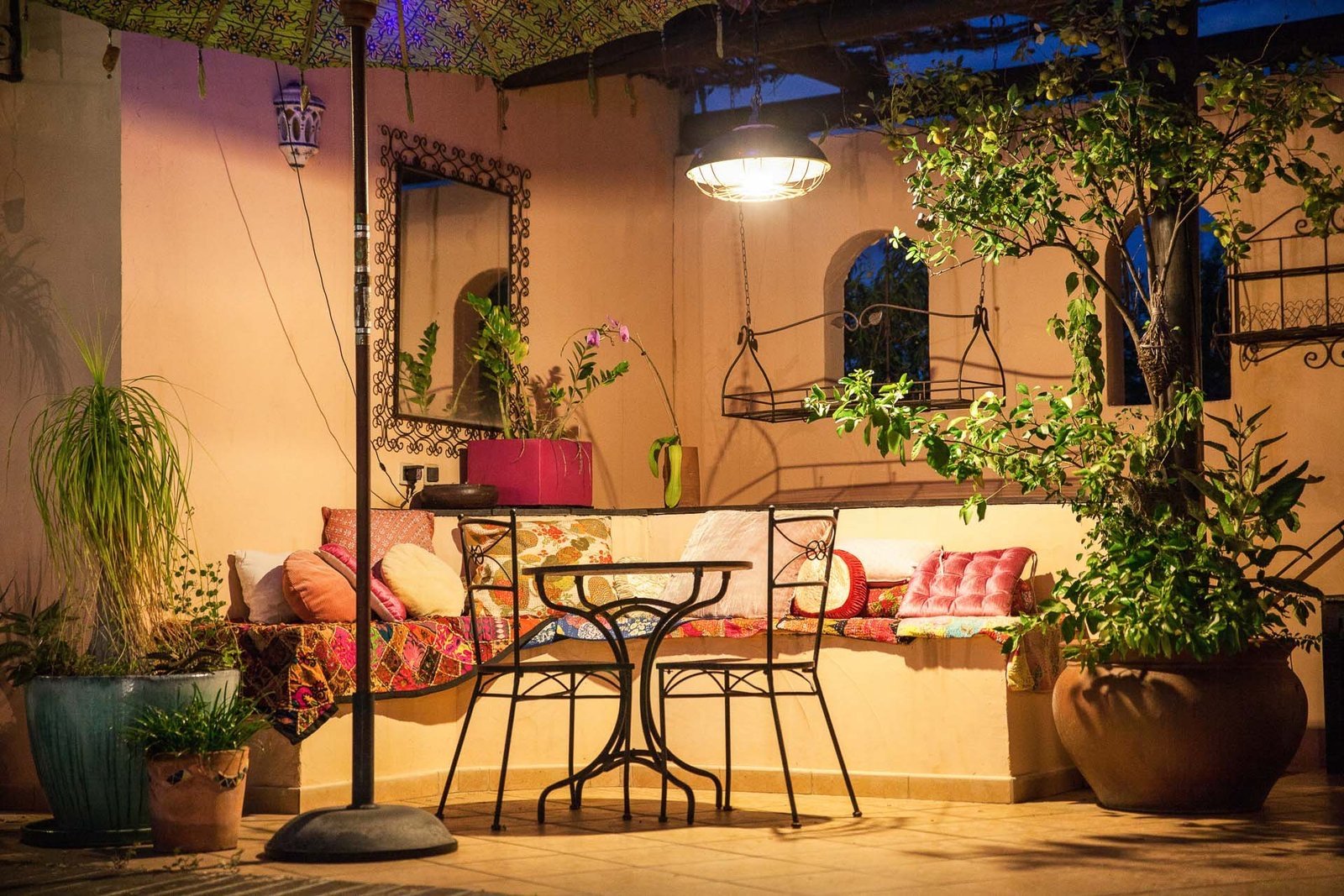 Terrasse extérieure photographiée de nuit, éclairée à la lanterne.