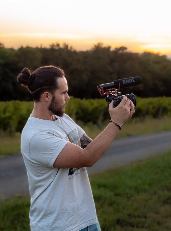 Jonathan Louis filmant dans les vignes au coucher du soleil.
