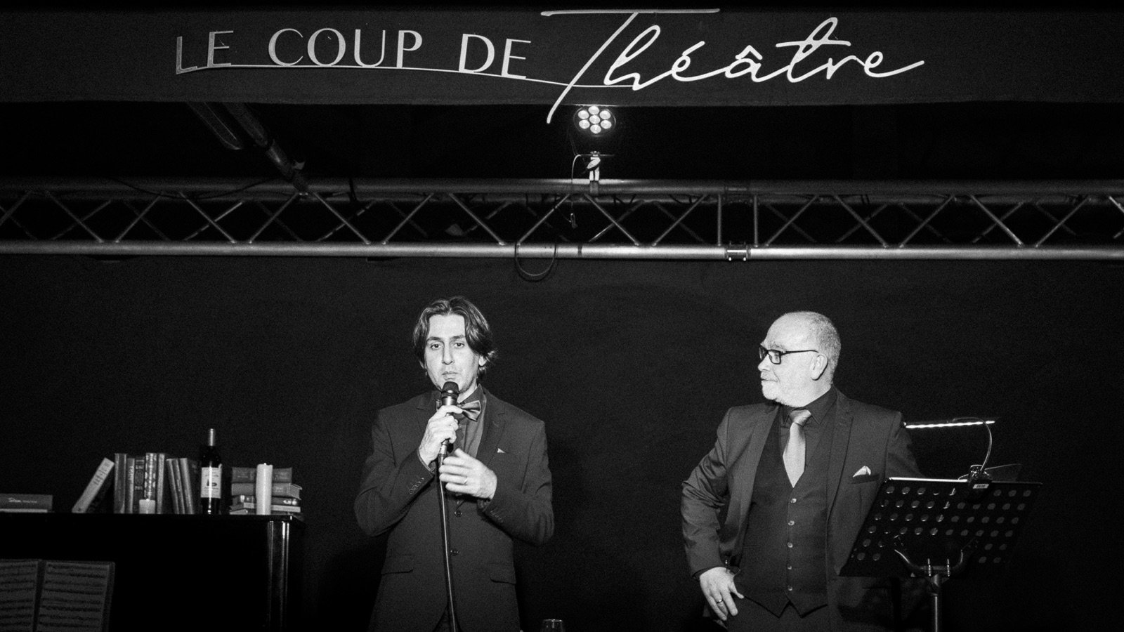 Les deux interprètes sous l’enseigne lumineuse.